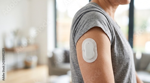 Person Wearing Continuous Glucose Monitor Patch on Arm Indoors, Symbolizing Health Monitoring, Diabetes Management, and Modern Medical Technology