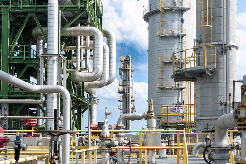Complex industrial pipeline networks and distillation towers at a petrochemical refinery plant.