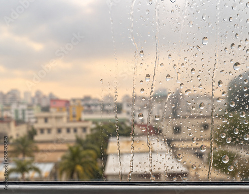 Rain droplets on glass overlooking an indistinct city skyline