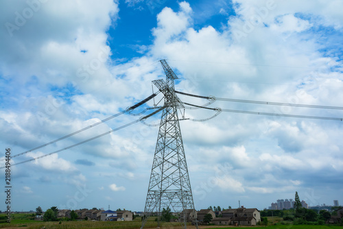 Fotografía High voltage transmission tower standing in countryside under blue sky with whit