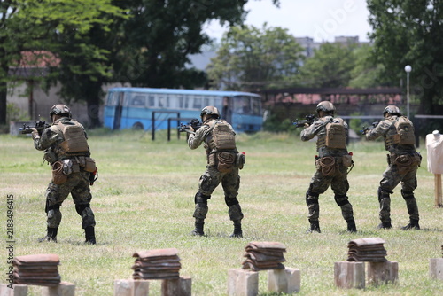 Armed special forces soldiers in camouflage tactical gear during a tactical combat exercise or combat operation
