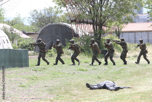 Armed special forces soldiers in camouflage tactical gear during a tactical combat exercise or combat operation