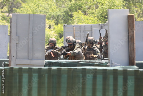 Armed special forces soldiers in camouflage tactical gear during a tactical combat exercise or combat operation