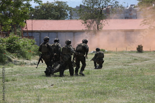 Armed special forces soldiers in camouflage tactical gear during a tactical combat exercise or combat operation