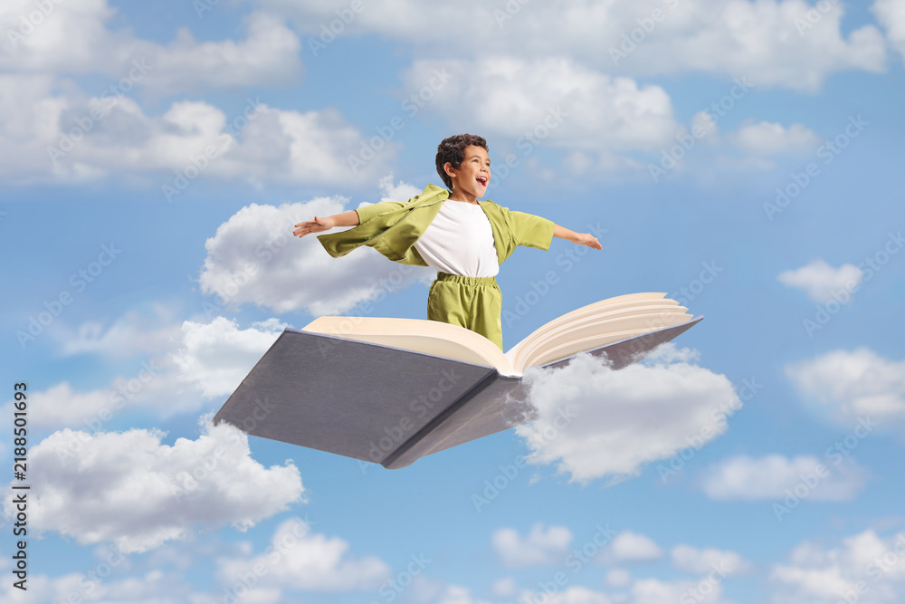Obraz premium Boy flying on an open book with arms spread