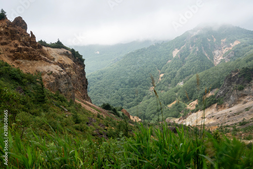 Foto 霧と薄雲に包まれる夏の毛無峠と荒々しい岩肌の山岳風景