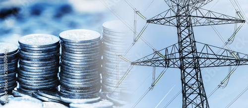 Electricity prices and power grid costs background. Stacks of coins beside high voltage transmission tower. Energy bills household expenses electricity market inflation utilities and consumer budget.