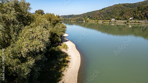 Canvastavla Aereal view of the River Danube in Upper Austria, a shore with pebbles and the sky reflecting in the water