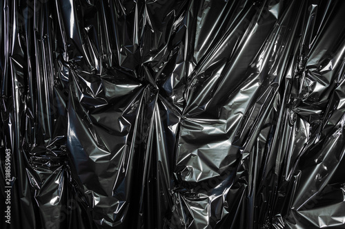 Foto Crumpled synthetic black plastic texture forming abstract background