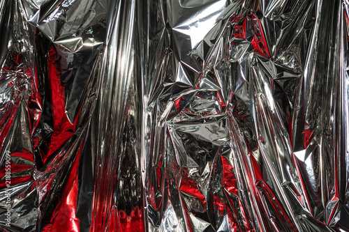 Fotografie Crumpled synthetic metallic and red texture forming abstract background