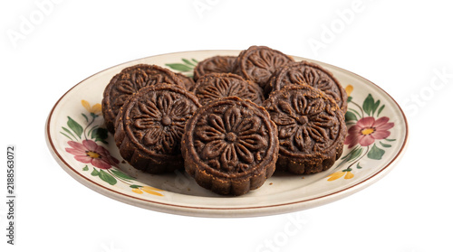 Authentic Brown Nolen Gur Sandesh with embossed floral patterns, on the plate isolated on crisp