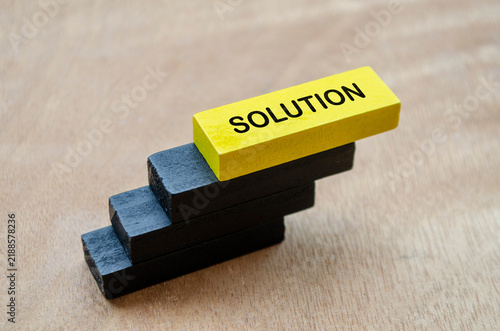Yellow and black wooden blocks representing innovative solutions, strategy, and problem resolution.