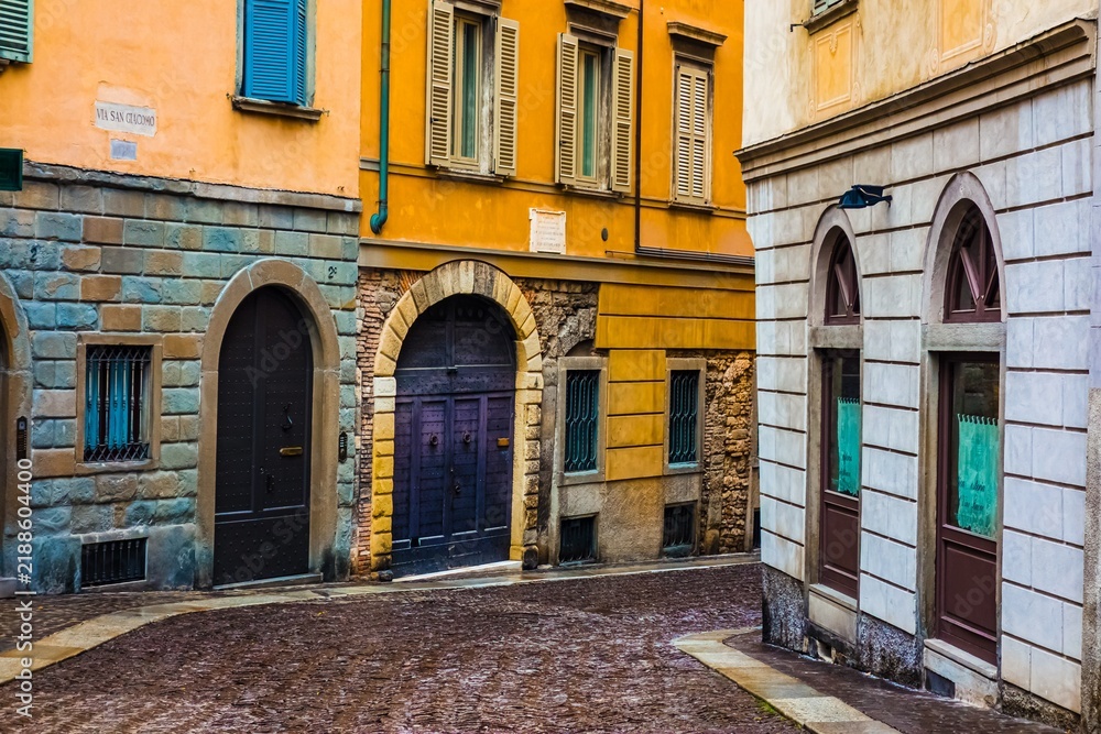 Fototapeta premium Cobblestone alley between colorful buildings