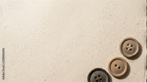 Three vintage sewing buttons on textured paper background