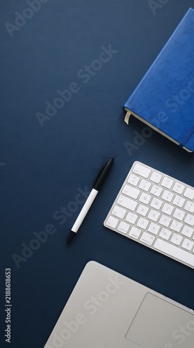 Minimal Blue Workspace with Notebook Pen and Computer Keyboard