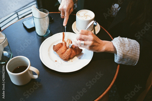 Enjoying Breakfast With Coffee and Croissant at a Cafe