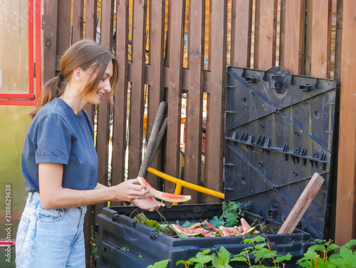 Woman adding food scraps and garden waste to compost bin