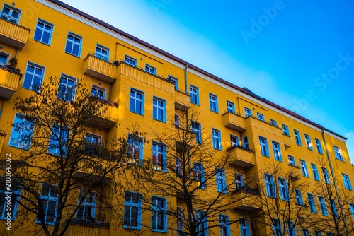 Bright yellow apartment building facade against blue sky