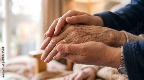 Two people holding hands gently showing care and compassion indoors