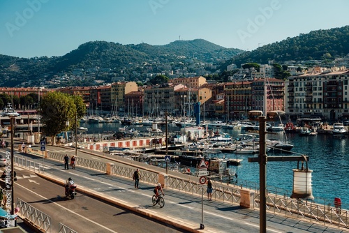 Sailboats and motorboats moored in calm Mediterranean waters along the waterfront in Menton, France. Warm sunlight illuminates the French Riviera coastline in September 2026.