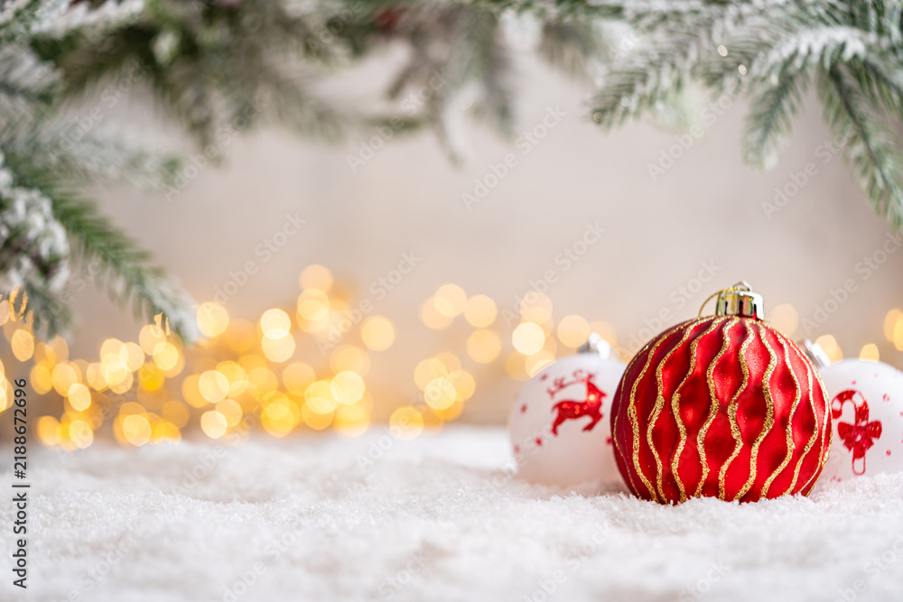 Obraz premium A Christmas background featuring a red plaid snowflake bauble beside white ornaments painted with a reindeer and candy cane beneath frosted pine on snow, softly lit by warm twinkling lights.