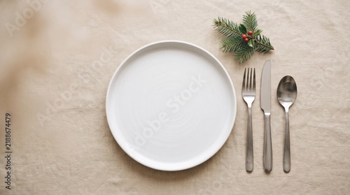 Elegant table setting with empty plate silverware and minimalist greenery for a fine dining experience