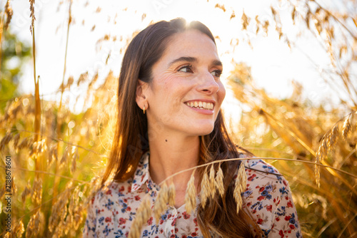Fotografie Smiling woman enjoying golden hour in nature