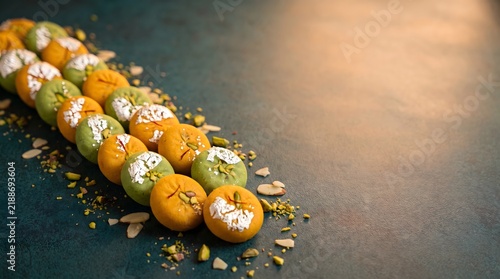 Traditional indian sweets called laddu arranged beautifully for the festive celebration of diwali on a dark textured background surface