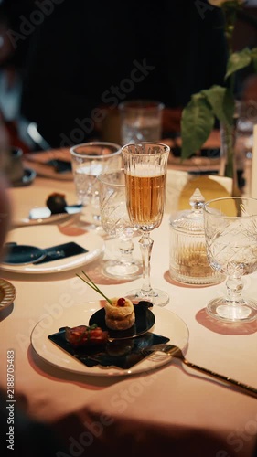Close up of elegant dining table with appetizer and glass of sparkling wine