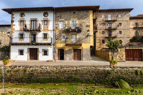Traditional houses lining the waterfront promenade along the Asón River. Limpias, Cantabria, Spain.