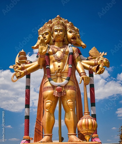 Canvastavla Intricate Multi-Armed Hindu Deity Statue Against a Blue Sky