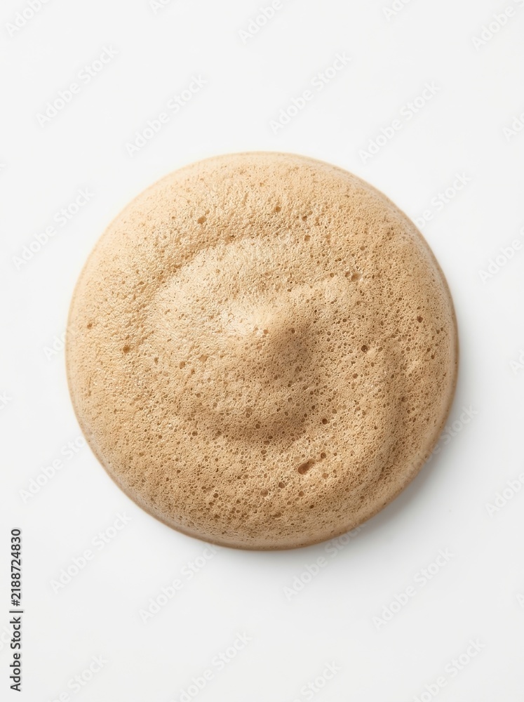 Fototapeta premium Top View of a Circular Dollop of Light Brown Cosmetic Foam or Creamy Mousse Isolated on White Background