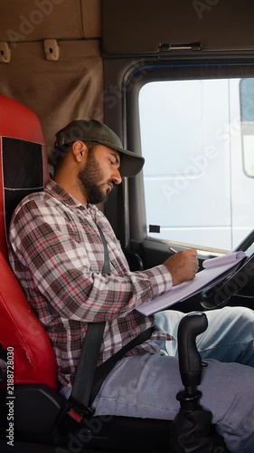 Professional truck driver checking documents and paperwork in cabin