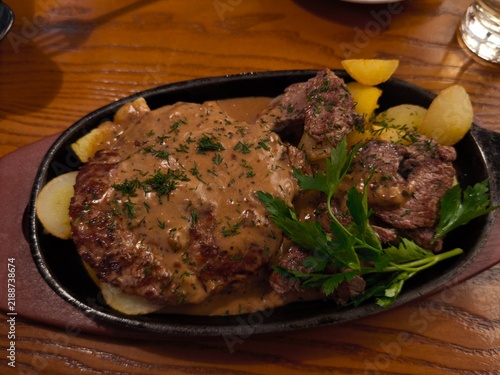 Foto A delicious restaurant dish featuring a tender grilled beef patty and sliced mea