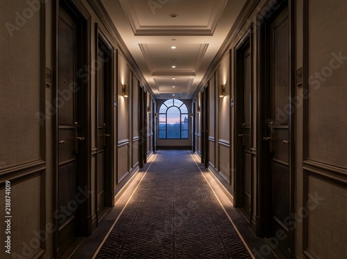 Elegant empty luxury hotel hallway with ornate doors and plush carpeting.