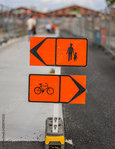 Фотография Orange temporary signs separate pedestrian and bicycle construction routes
