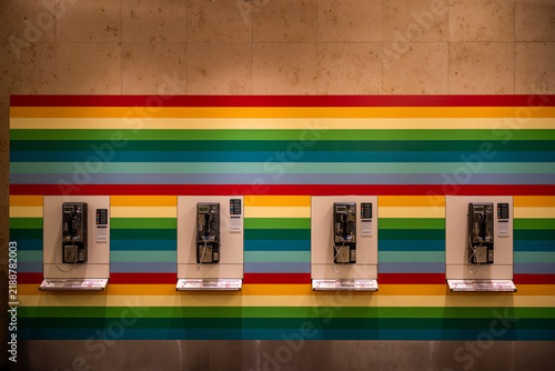 Fotografie Four vintage payphones on a colorful striped wall background.
