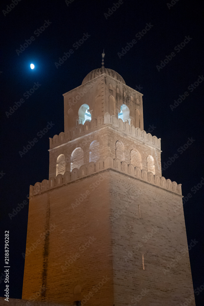 Obraz premium Moon behind the minaret on the Great Mosque of Kairouan in the medina, in Kairouan, Tunisia, at night
