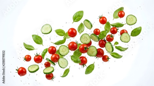 Floating Fresh Cherry Tomatoes Sliced Cucumbers and Green Basil on White