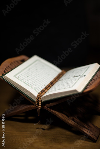 pages of holy koran and rosary at the book