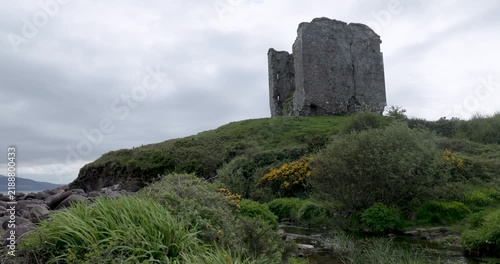 Stone tower ruin on a grassy Irish hillside