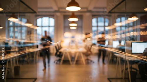 Blurred view of employees working in a contemporary open plan office interior with office workplace