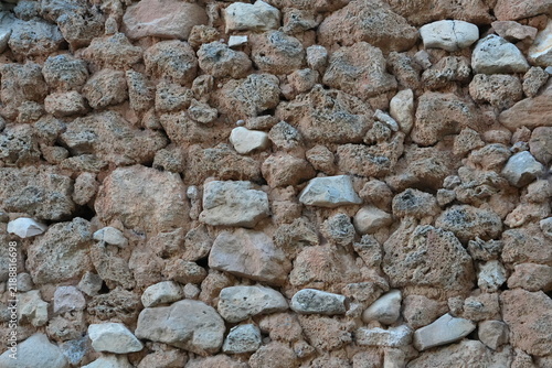Canvas Print Rustic stone masonry wall made of irregular porous rocks