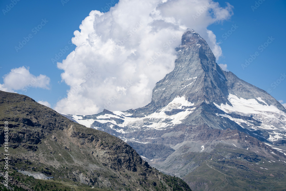 Fototapeta premium Matterhorn peak with cumulus clouds in summer telephoto view