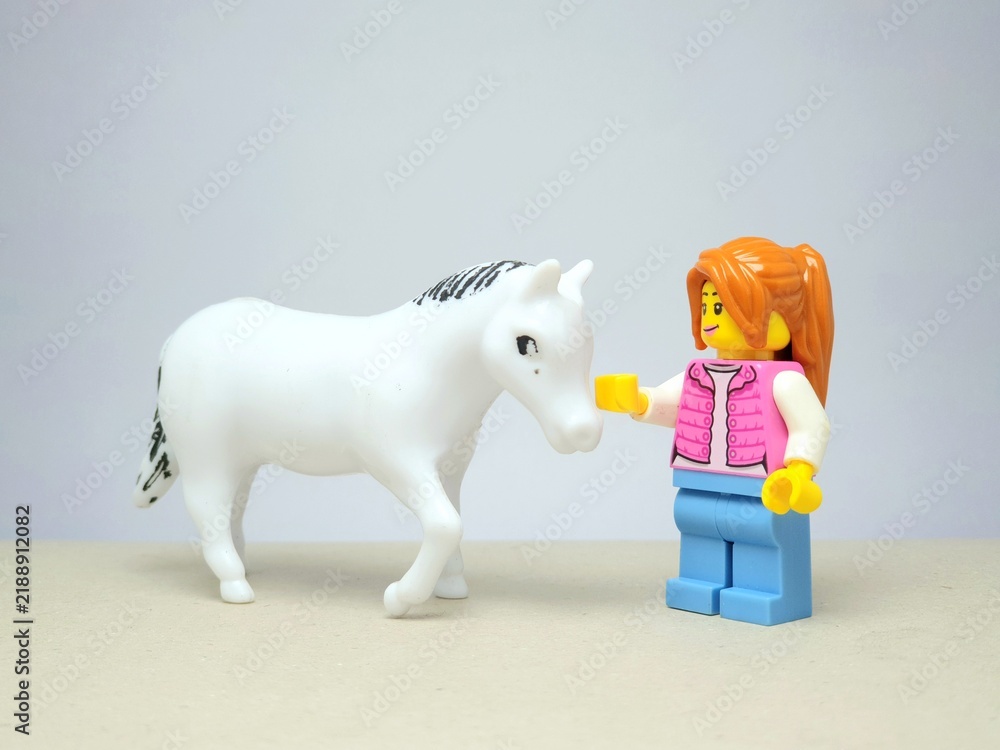 Fototapeta premium Indonesia - December 1, 2023 : Mini toy figure of people at table with blurred background. Miniature photography concept design. Horse Jockey concept.