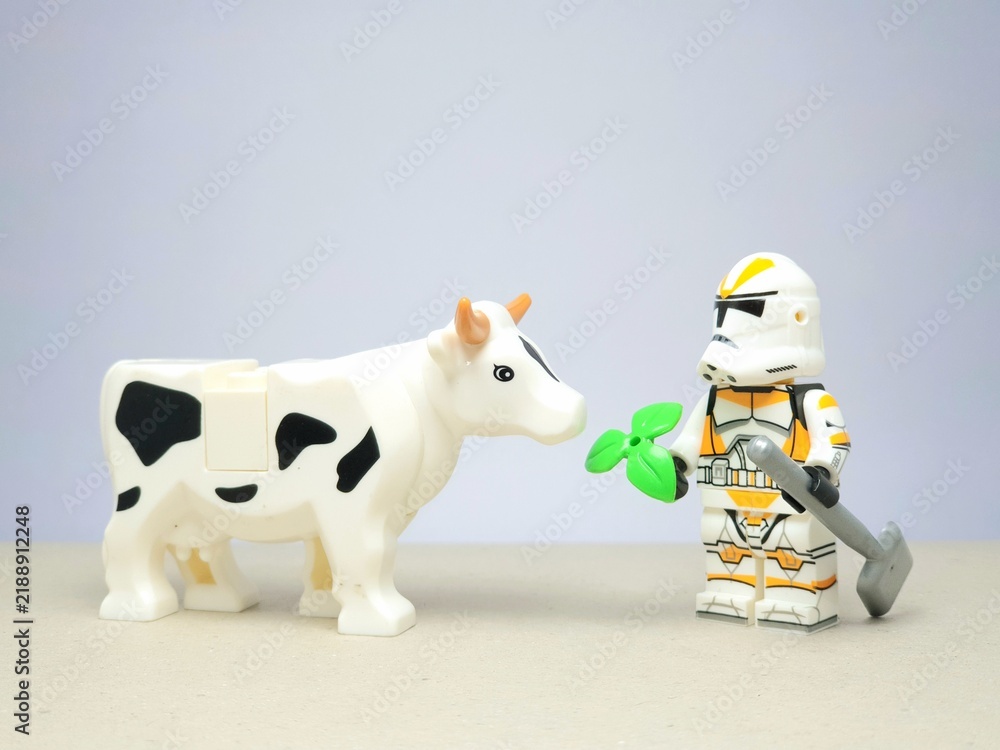 Obraz premium Indonesia - December 1, 2023 : Mini toy figure of people at table with blurred background. Miniature photography concept design. Farmer give green leaves plant.