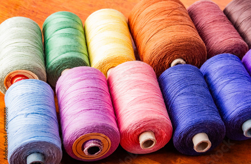 Foto Photo of various colored cotton threads laying on table in a row.
