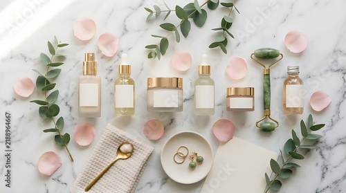 A flat lay aesthetic of premium organic skincare products arranged on a luxurious white marble surface with eucalyptus leaves and floral petals