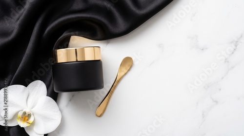 Flat Lay of Luxury Cosmetic Jars, Golden Spatula, and Silk Fabric Swatches