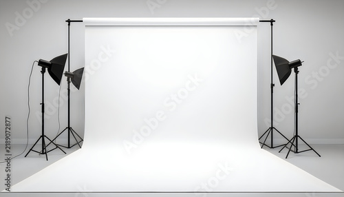 Empty white studio backdrop with professional lighting equipment for photography.